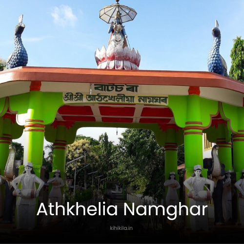 Entrance gate of Athkhelia Naamghar in Assam, featuring traditional Assamese architecture with yellow and red pillars, statues of Vaishnavite saints, and peacock sculptures. A deity figure stands atop a lotus on the roof, symbolizing spirituality.