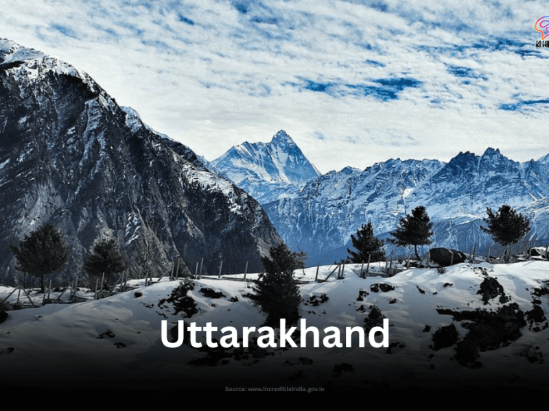 The snow-covered slopes of Auli, Uttarakhand, with a majestic view of the Himalayan peaks under a vast, cloudy sky.