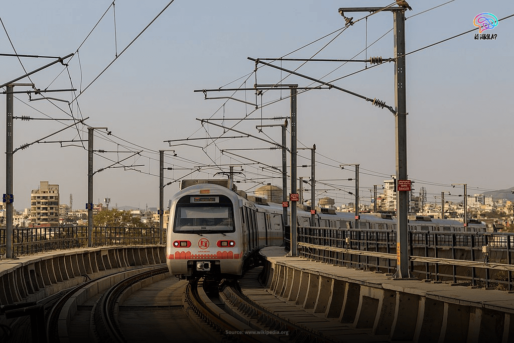 A modern Jaipur Metro train moving on elevated tracks with the city skyline in the background, illustrating urban transportation in Rajasthan.