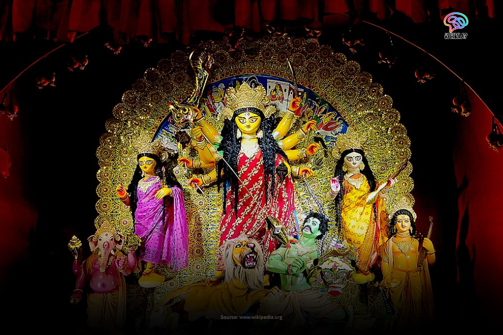 An ornate idol of the ten-armed Hindu goddess Durga with her children, beautifully illuminated in a pandal during the Durga Puja festival in West Bengal.