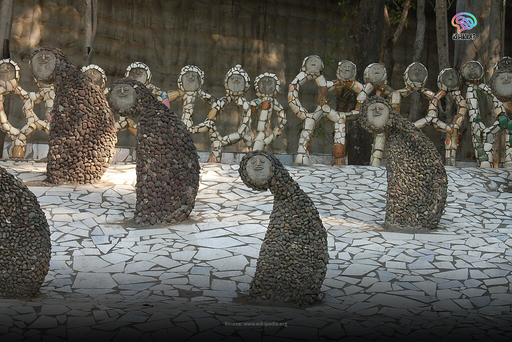 Chandigarh: The Inspiring Blueprint of India’s Urban, Cultural & Educational Excellence 4 Sculptures of women in a courtyard at the Rock Garden in Chandigarh, made from recycled ceramic and tile pieces, with a waterfall in the background.