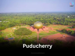 An aerial view of the Matrimandir in Auroville, Puducherry, surrounded by lush green landscapes.