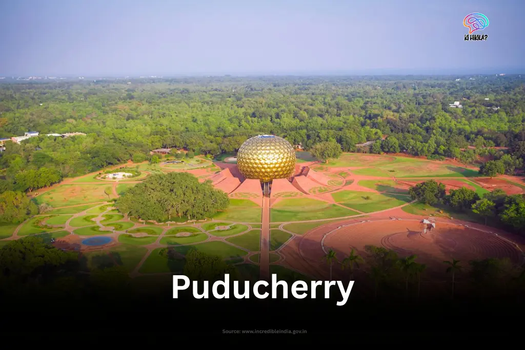 An aerial view of the Matrimandir in Auroville, Puducherry, surrounded by lush green landscapes.